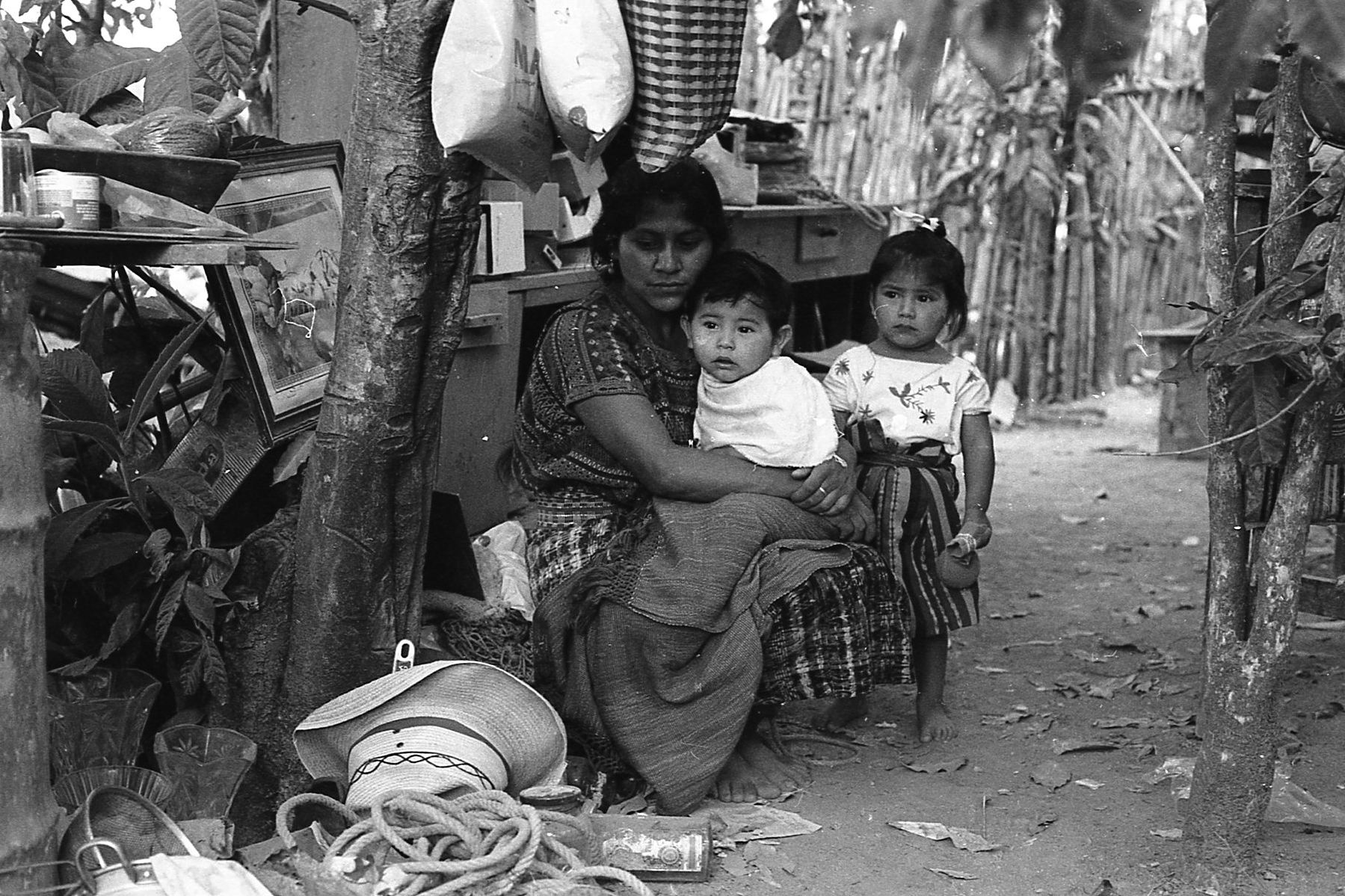 A mother comforts her son and daughter. B/W